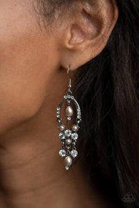 Paparazzi Back In The Spotlight - Brown Earrings - Glittery white rhinestones and pearly brown beaded fittings delicately swing from the bottom of an ornately embellished oval frame. A matching pearly frame dangles from the top of the decorative silver frame, adding timeless movement to the sparkly display. Earring attaches to a standard fishhook fitting.