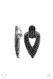 Paparazzi Blinged Out Buckles - Black Clip-On Earrings - The front of a spade shaped silver frame is encrusted in row after row of glittery black rhinestones, creating a blinding buckle inspired statement piece. Earring attaches to a standard clip-on fitting.