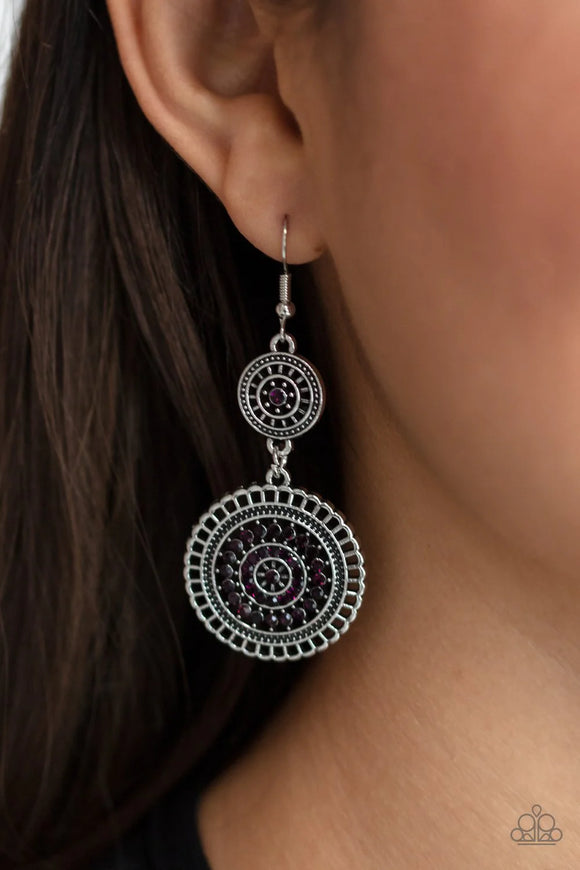 The centers of silver wheel-like frames are bedazzled in glittery purple rhinestones, creating a glamorous display as the frames link into a sparkly lure. Earring attaches to a standard fishhook fitting.