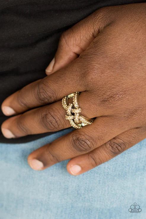Paparazzi Can Only Go UPSCALE From Here - Brass Ring - Encrusted in golden topaz rhinestones, shimmery brass bars crisscross across the finger, coalescing into a bold square knot atop the finger. Features a stretchy band for a flexible fit.