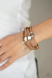 Paparazzi Canyon Flight - White Bracelet - Infused with a dainty silver bird charm, dainty strands of brown suede are adorned in mismatched silver accents and white stones for an earthy layered look. Features an adjustable clasp closure.