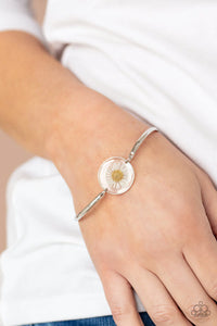 Paparazzi Cottage Season - White Bracelet - Encased in a glassy fitting, a whimsical white daisy centerpiece attaches to two arcing silver bars around the wrist for an enchanting floral look. Features an adjustable clasp closure.