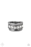 Paparazzi Dauntless Shine - Black Gunmetal - Ring - Infused with dainty gunmetal studs, a row of glassy white rhinestones is boldly displayed along the center of a beveled gunmetal band for a fierce look. Features a stretchy band for a flexible fit.