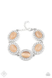 Paparazzi Demurely Diva - Orange Bracelet - Dotted with glowing Peach Nougat cat's eye stone centers, glassy white rhinestone encrusted frames glamorously link around the wrist in a sparkly statement-making fashion. Features an adjustable clasp closure.