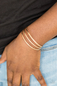 Paparazzi Eastern Empire - Gold Bracelet - Etched in shimmery geometric patterns, glistening gold bars arc across the wrist, coalescing into a dainty cuff.