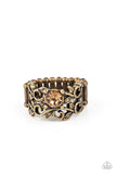 Paparazzi Ebb And GLOW - Brass Ring - An oversized topaz rhinestone adorns a leafy brass backdrop of two topaz rhinestone dotted bands, coalescing into a whimsical centerpiece. Features a stretchy band for a flexible fit.
