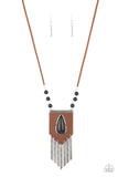 Paparazzi Enchantingly Tribal - Black - Necklace  A bold black teardrop stone encased in an antiqued silver frame is centered on a brown leather insignia-like pendant. Decorated with a silver plate embossed in geometric designs and a tinkling fringe of embossed silver plates suspended from the bottom, the pendant sways from lengthened leather cords accented with black stone beads for an enchantingly timeless finish. Features an adjustable clasp closure.