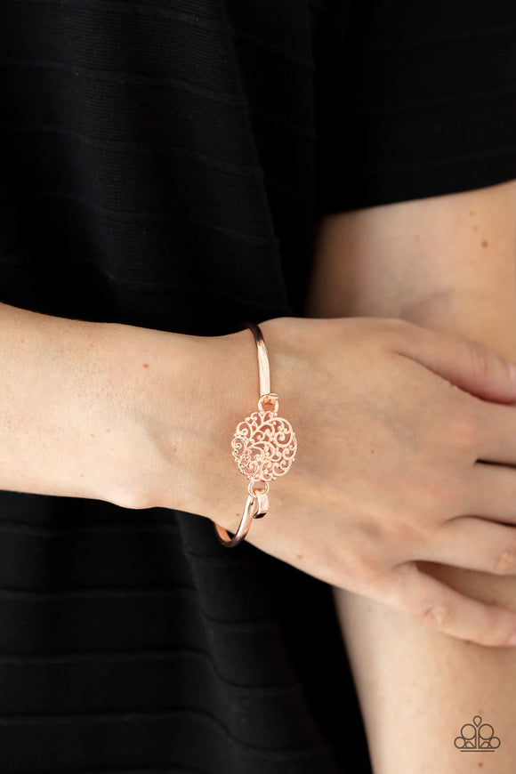 Paparazzi Filigree Fiesta - Gold Bracelet - Shiny rose gold filigree swirls into a round frame that hooks to a dainty rose gold bangle-like cuff, creating a whimsical centerpiece. Features a hinge-like closure.