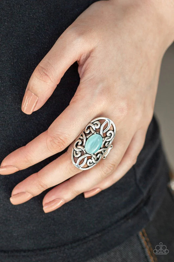 Paparazzi GLEAM Big - Blue Ring - A glowing blue cat's eye stone is pressed into the center of an oval backdrop swirling with vine-like filigree for a whimsical look. Features a stretchy band for a flexible fit.