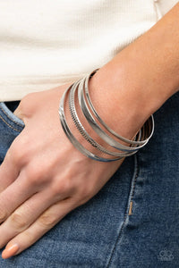 Paparazzi Gliding Gleam - Silver Bracelet - A set of gleaming silver smooth and textured bangles twinkle and chime as they stack up the wrist for a striking finish.