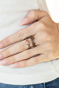 Paparazzi Heartstring Harmony - Copper Ring - Brushed in an antiqued shimmer, a glistening copper ribbon spells out the word, "love," atop a copper band dotted with a dainty copper heart center for a romantically rustic look. Features a stretchy band for a flexible fit.