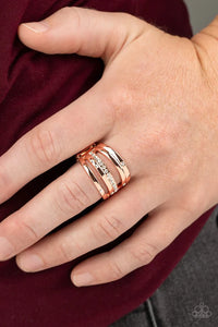 Paparazzi Make A SHEEN - Copper Ring - Dainty white rhinestones are sporadically sprinkled across rows of shiny copper bands abstractly layered across the finger for a refined twist. Features a stretchy band for a flexible fit.