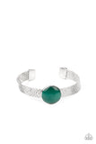 Paparazzi Mystical Magic - Green Bracelet - A glassy green cat's eye stone frame sits atop a layered silver cuff that is etched in shimmery textures, creating a glittery centerpiece.
