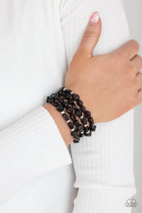 Paparazzi Nice GLOWING - Black Bracelet - Glossy black irregularly shaped beads in varying opacities, accented with shining faceted silver beads are threaded along stretchy bands and stack up the wrist for a glowing display.