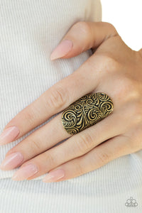 Embossed in an antiqued paisley pattern, a thick brass frame folds around the finger for a whimsically retro look. Features a stretchy band for a flexible fit.