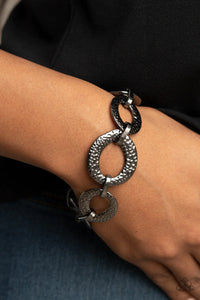 Paparazzi STEEL The Show - Black Gunmetal Bracelet - Asymmetrical gunmetal links and hammered oval frames delicately connect around the wrist for an intense industrial look. Features an adjustable clasp closure.