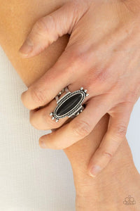 Paparazzi Sahara Escape - Black Ring - An oblong black stone is pressed into the center of a rustic silver frame radiating with studded and metallic ropelike textures, creating a seasonal centerpiece atop the finger. Features a stretchy band for a flexible fit.