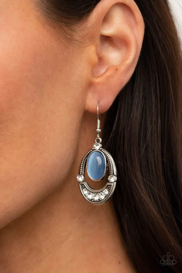 Paparazzi Serene Shimmer - Blue Earrings - A glowing blue cat's eye stone attaches to the top of a studded silver frame. The bottom of the oval is encrusted in glassy white rhinestones, creating a whimsical display. Earring attaches to a standard fishhook fitting.