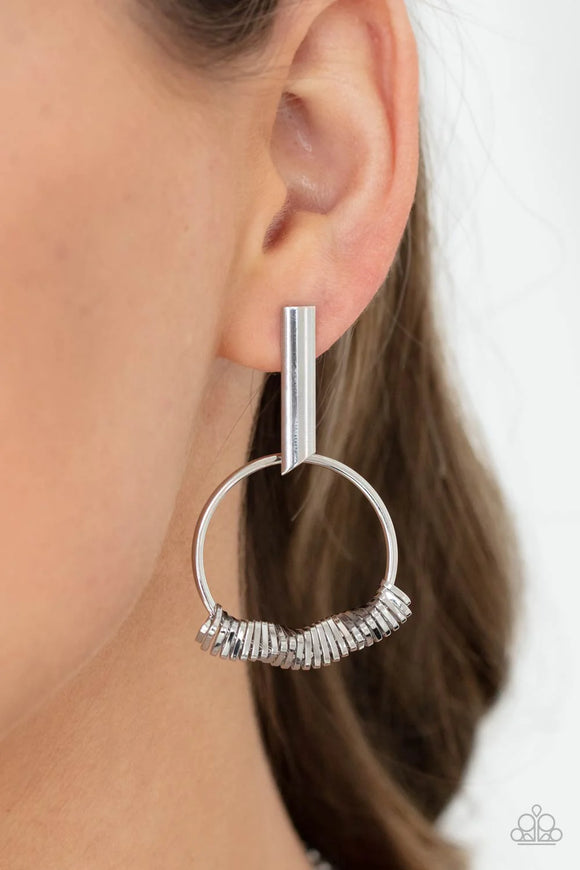 Paparazzi Set Into Motion - Silver Earrings - Glistening silver triangular rings are delicately fitted in place along the bottom of a dainty silver hoop, creating the illusion of twisting movement. The edgy hoop links to a silver rectangular hoop, creating an edgy lure. Earring attaches to a standard post fitting.