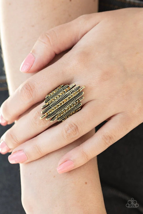 Paparazzi Shocking Sparks - Brass Ring - Studded and aurum rhinestone encrusted brass bars alternate across the finger, stacking into an electrifying centerpiece. Features a stretchy band for a flexible fit.