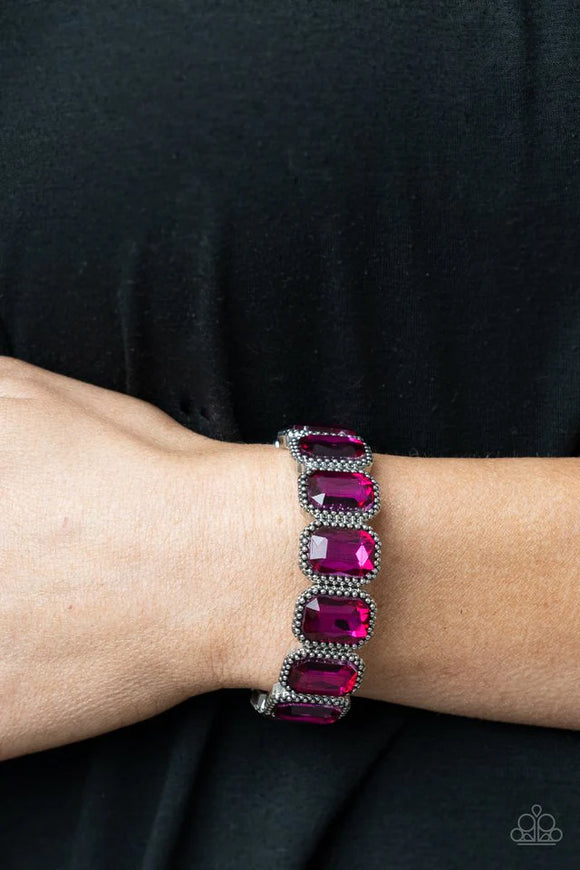 Paparazzi Studded Smolder - Pink Bracelet - Oversized emerald style pink gems are encased in antiqued studded frames that are threaded along stretchy bands around the wrist, creating a smoldering centerpiece.  Dazzling Pink Emerald cut stones detailed with silver boarder make this adjustable stretchy bracelet irresistible. 