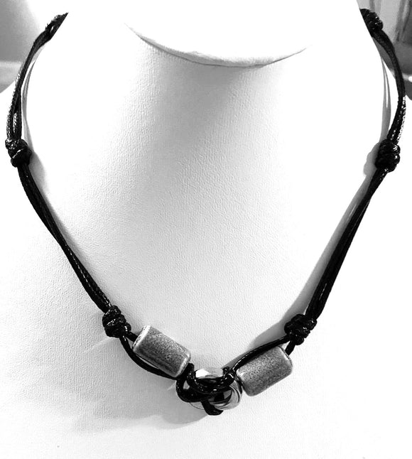 Paparazzi The Broncobuster - Black Necklace - Shiny black cording knots around glassy gray beads and a burnished silver ring, creating an urban look below the collar. Features a button loop closure.