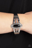 Paparazzi Wanderlust Walkabout - Black Bracelet - An oval black bead is pressed into the center of a textured silver frame atop a layered silver cuff stamped in swirly texture, resulting in a trendy pop of color around the wrist.