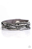 Paparazzi Too Cool For School - Silver - Bracelet  -  A gray strip of suede is spliced into glittery bands braided across the wrist in a sassy fashion. Round hematite rhinestones and emerald-cut hematite beading create the ultimate collision of sparkle. Features an adjustable snap closure.

