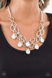 Paparazzi Show-Stopping Shimmer - White Joined by dainty silver links, two rows of dramatic silver chain layer below the collar in a fierce fashion. Glittery white teardrops drip from the glistening layers, adding a timeless shimmer to the show-stopping piece. Features an adjustable clasp closure.
