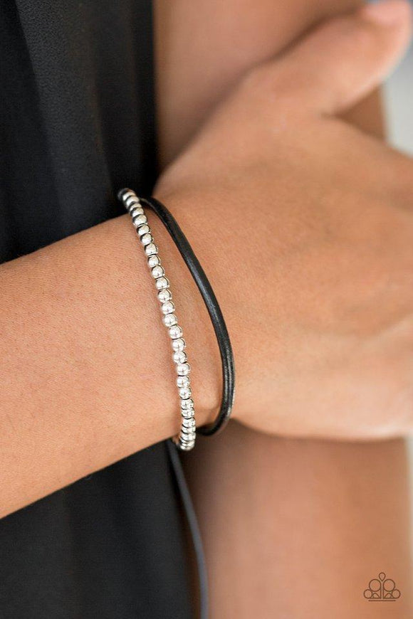 Paparazzi Mountain Mod - Black A strand of glistening silver beads and a strand of shiny leather cording wrap around the wrist, creating dainty layers. Features an adjustable sliding knot closure.


