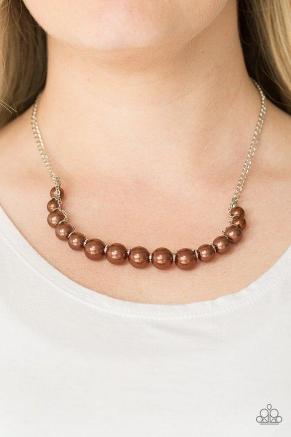 Paparazzi The FASHION Show Must Go On - Brown A classic strand of brown pearls is threaded along an invisible string, creating a stationary pendant below the collar. Infused with shimmery silver accents, silver chain weaves atop the pearls for a refined finish. Features an adjustable clasp closure.

