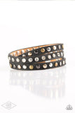 Paparazzi Lets Go For A CATWALK - Black - Bracelet  -  A skinny strip of black leather is encrusted in sections of glittery white rhinestones and flat brass, gold, and silver studs. The elongated band double wraps around the wrist for a fierce one-of-a-kind look. Features an adjustable snap closure.