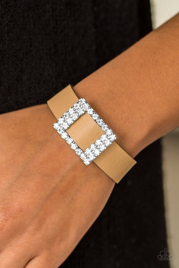 Paparazzi Diamond Diva - Brown - Bracelet  -  Encrusted in glassy white rhinestones, a dazzling frame slides along a strip of brown leather, creating a blinding centerpiece atop the wrist. Features an adjustable snap closure.
