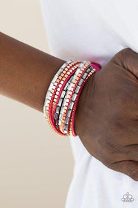 Paparazzi This Time With Attitude - Pink Smoky and white emerald cut rhinestones and flat gold cube beads are encrusted along strands of pink suede for a sassy look. The elongated band double wraps around the wrist for a fierce one-of-a-kind look. Features an adjustable snap closure.


