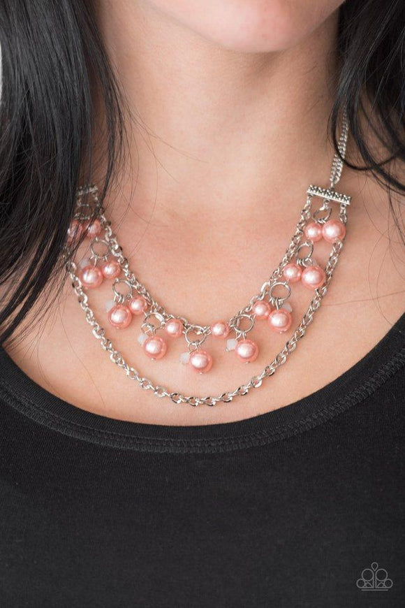 Paparazzi Rockefeller Romance - Orange Attached to two floral fittings, rows of shimmery silver chains flank a pearly beaded strand below the collar. Dramatic coral pearls and faceted crystal-like beads swing from the centermost strand for a refined finish. Features an adjustable clasp closure.
