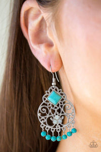 Paparazzi Western Wonder - Blue Dotted with opaque rhinestones and a square turquoise stone bead, vine-like silver filigree climbs a shiny silver frame. Refreshing turquoise stone beads swing from the bottom of the frame, creating a free-spirited fringe. Earring attaches to a standard fishhook fitting.

