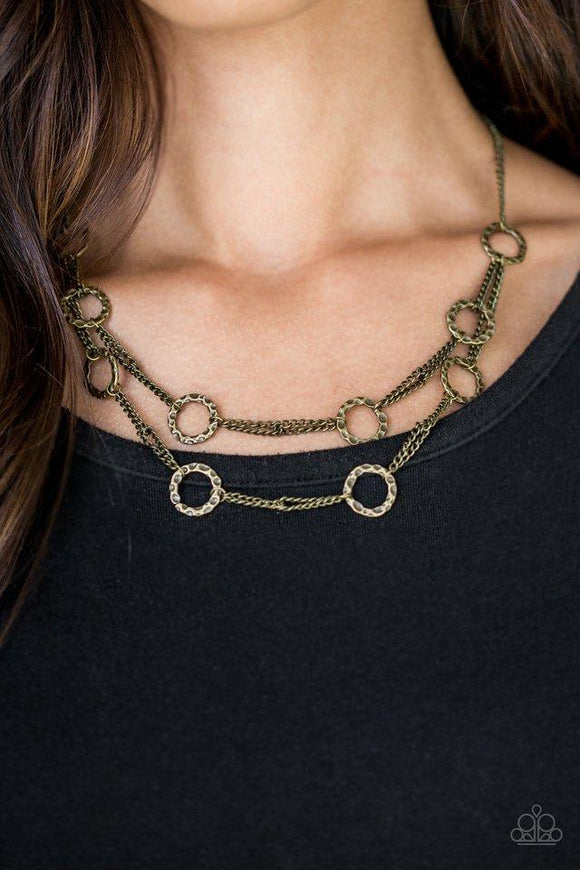 Paparazzi Circus Couture - Brass Delicately hammered in shimmer, rows of shiny brass hoops join with chain-like links below the collar for a sleek industrial look. Features an adjustable clasp closure.

