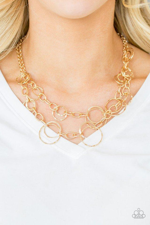 Paparazzi Urban Center - Gold Mismatched gold hoops and rings link into two shimmery rows below the collar for a bold industrial look. Features an adjustable clasp closure.

