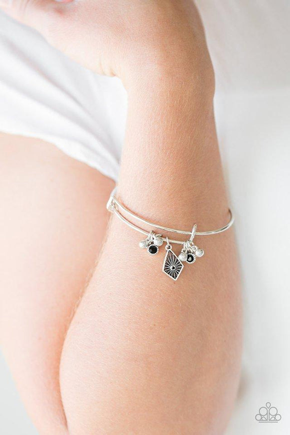 Paparazzi Treasure Charms - Black A collection of shimmery silver beads and glittery black rhinestone accents slide along a sleek bar fitting, creating whimsical charms as they glide along the dainty silver bangle.
