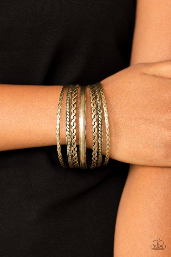 Paparazzi Rattle and Roll - Brass Featuring an array of tribal inspired textures, mismatched brass bangles stack across the wrist for a seasonal look.

