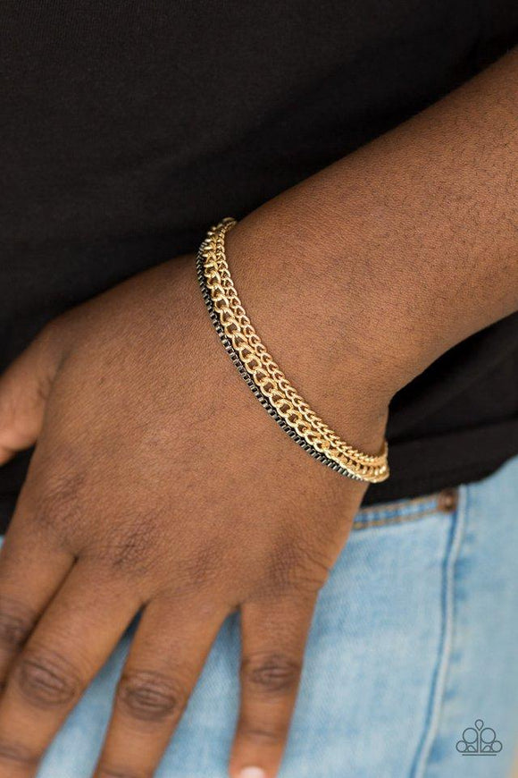 Paparazzi Industrial Icon - Gold  -  Dainty gunmetal box chain and mismatched gold chains layer across the wrist, creating a collision of industrial textures. Features an adjustable clasp closure.
