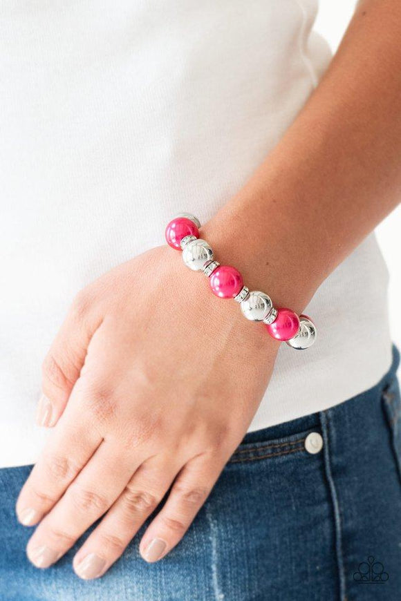 Paparazzi So Not Sorry - Pink  -  A collection of white rhinestone encrusted rings, pink pearls, and classic silver beads are threaded along a stretchy band around the wrist for a glamorous look.
