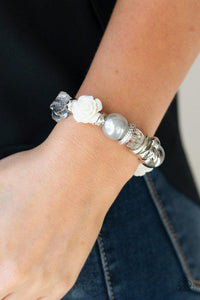 Paparazzi Here I Am - Silver  -  A collection of silver, pearly silver, and white crystal-like beads are threaded along a stretchy band around the wrist. A shiny white resin rose joins the refined palette for a glamorous finish.
