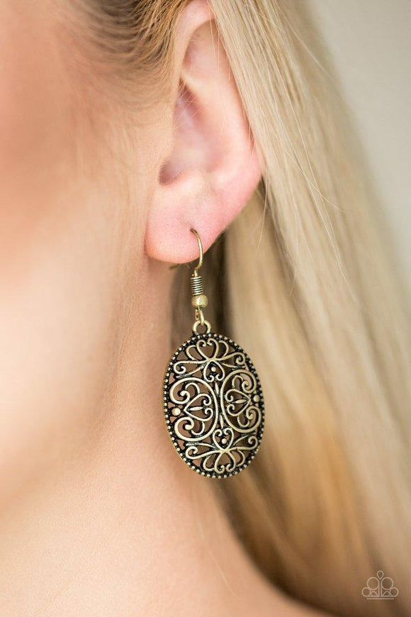 Paparazzi Wistfully Whimsical - Brass Glistening brass filigree climbs an oval brass frame, creating a whimsical lure. Earring attaches to a standard fishhook fitting.
