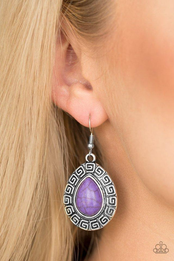 Paparazzi Tribal Tango - Purple Chiseled into a tranquil teardrop, a vivacious purple stone is pressed into the center of a silver frame embossed in spiraling patterns for a tribal look. Earring attaches to a standard fishhook fitting.

