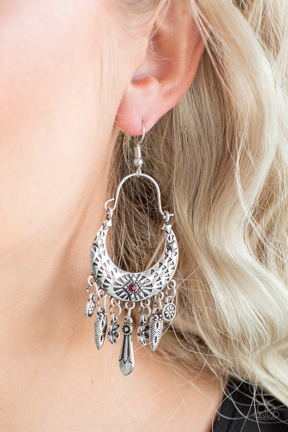 Paparazzi Nature Escape - Red - Earrings  -  Stamped in triangular textures, a shimmery silver crescent frame gives way to a fringe featuring glistening floral and abstract charms. Suspended by a dainty wire fitting, the tribal inspired frame is dotted with a dainty red rhinestone for a colorful finish. Earring attaches to a standard fishhook fitting.
