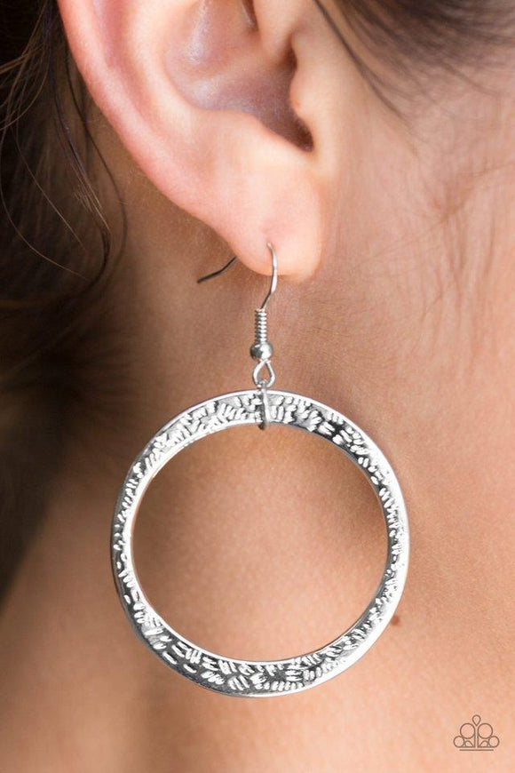 Paparazzi Wildly Wild Lust- Silver Delicately hammered in light-catching detail, an asymmetrical silver hoop swings from the ear for an artisan inspired look. Earring attaches to a standard fishhook fitting.

