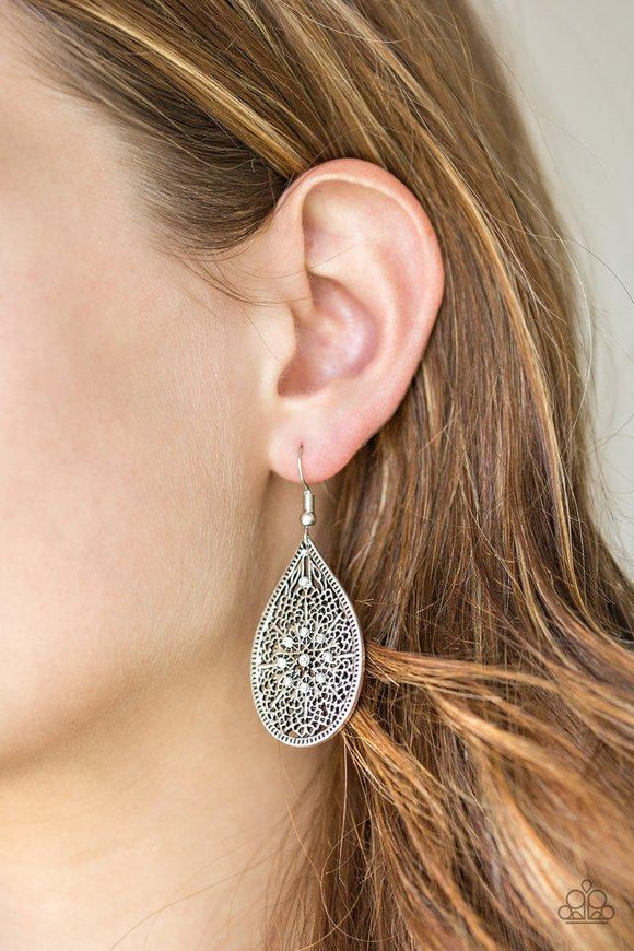 Paparazzi Dinner Party Posh - White Featuring an elegant filigree filled backdrop, a shimmery silver teardrop swings from the ear. Dainty white rhinestones are sprinkled across the frame for a glamorous finish. Earring attaches to a standard fishhook fitting.

