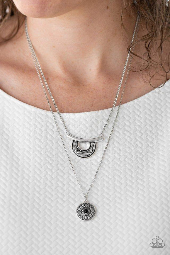 Paparazzi Gypsy GoGetter- Black Radiating with linear patterns, a shimmery silver frame swings from the uppermost chain above a silver disc radiating with floral detail. A dainty black bead dots the center of the lowermost pendant for a colorful finish. Features an adjustable clasp closure.


