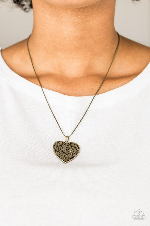 Paparazzi Look Into Your Heart- Brass Filled with vine-like filigree detail, a brass heart pendant swings below the collar for a vintage inspired look. Features an adjustable clasp closure.

